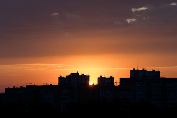 Orange sky. Morning in town. Panorama of the metropolis. Silhouette of houses. Peaceful life. Calm sky. Color gradient in nature. Heavenly landscape. Urban skyline.