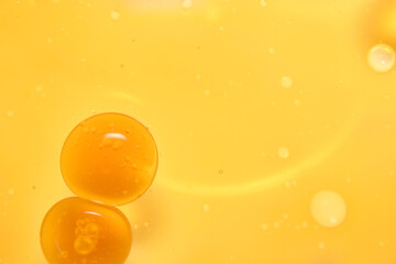 Close-Up of Yellow Oil Droplets Floating in Bright Liquid Background