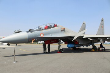 A detailed view of a modern fighter jet parked on an airport apron, with its sleek profile and...