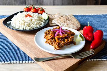 Home cooked beef chilli dish with rice, pitta bread and tomatoes and red onions
