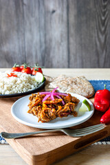 Home cooked beef chilli dish with rice, pitta bread and tomatoes and red onions