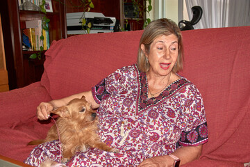 A heartwarming scene with a grandmother and her red-haired dog demonstrating unity and affection in the living room of a family home.