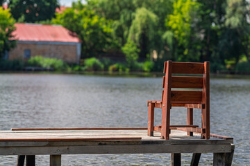 A chair on a river pier.