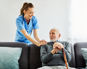 Doctor or nurse caregiver's hand giving support to a senior man at home or nursing home