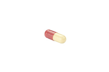 A single red and white antibiotic capsule pill, a common prescription drug for infection treatment. Macro of a pharmaceutical medicine, isolated on white background with clipping path.