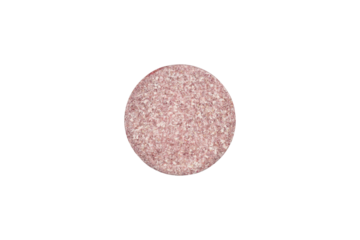 Pink speckled round pill shown in macro detail. This tablet represents medicine for women's health, children's vitamins, or other specific treatment, isolated on white background with clipping path.