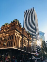 Contraste architectural à Sydney : vieux bâtiment historique au premier plan et tour moderne en arrière-plan