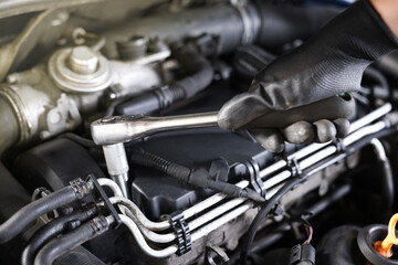 Auto parts. Professional mechanic with torque wrench fixing car indoors, closeup