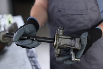 Auto part. Professional mechanic with manual transmission indoors, closeup