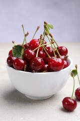 Wet ripe cherries on light table, closeup
