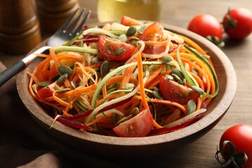 Tasty vegetable noodles served on wooden table, closeup