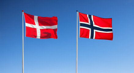 Norwegische und Dänische Nationalflagge vor blauem Himmel