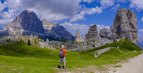 Hiker photographing Cinque Torri in the Dolomites of Italy