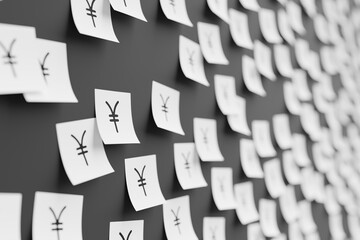 Many white stickers on black board background with symbol of Japan yen drawn on them. Closeup view...