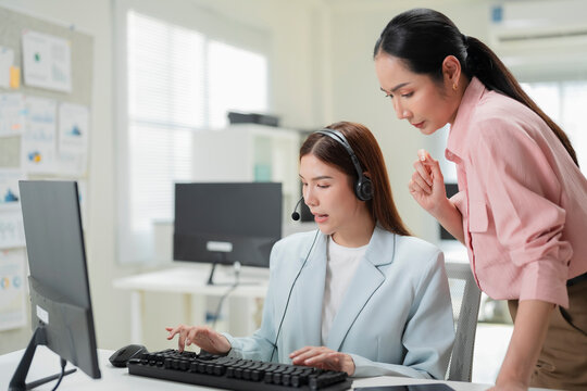Cheerful mature coworkers and confident operators cooperating on customer cases in call center, female customer service workers talking with supervisor and colleagues about customer service solutions