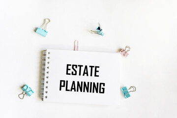 A notebook with the text Real estate planning. Paper clips on a white background. Business concept