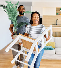 Young black couple moving into a new modern house, carrying boxes and arriving home together....