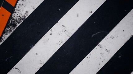 Black and white diagonal stripes creating a dynamic abstract composition, with orange accent