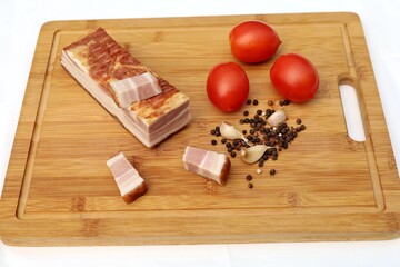 Sliced bacon with tomatoes, garlic and pepper.