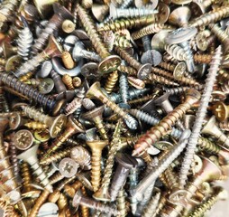 Texture, wallpaper photo, a pile of reisser screws in various sizes and colors, close up.