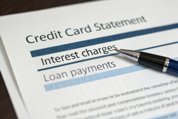 Credit card statement showing interest charges and loan payments with pen