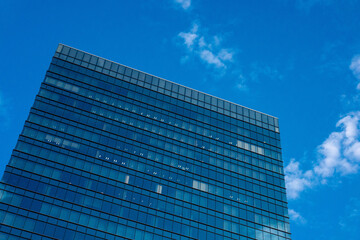 Fototapeta premium 空に映えるオフィスビル、青空に伸びる高層ビル
