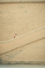 A happy  man is walking up the old bricks stairs to visit ancient historical park, concept elderly retired man lifestyle,freedom,travel,ecotourism,quality of life