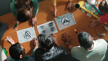 Top view of smart business team put graphic logo on meeting table and start to design while explain...