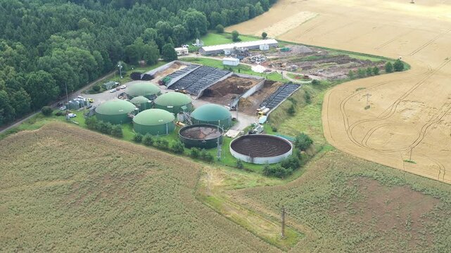 Biogas plant and farm in fields. Renewable energy from biomass. Agriculture prepared for Green Deal. Aerial view to Czech industry. Sustainable development in European Union.	