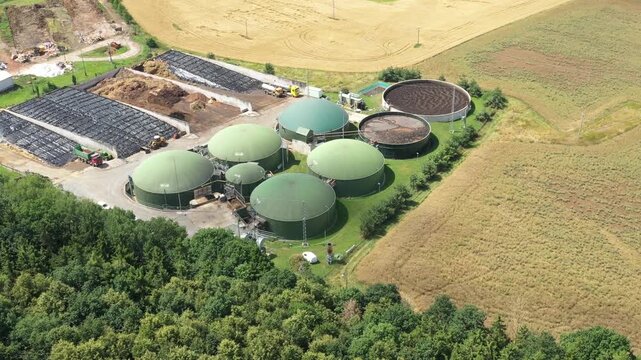 Biogas plant and farm in fields. Renewable energy from biomass. Agriculture prepared for Green Deal. Aerial view to Czech industry. Sustainable development in European Union.	