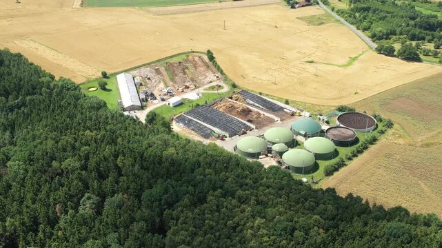 Biogas plant and farm in fields. Renewable energy from biomass. Agriculture prepared for Green Deal. Aerial view to Czech industry. Sustainable development in European Union.	