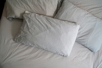 Pillows with fresh clean pillowcases, grey cotton bed sheets