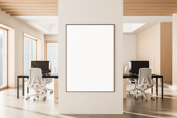 Blank poster mockup on white wall in modern office interior with wooden details and computers on...