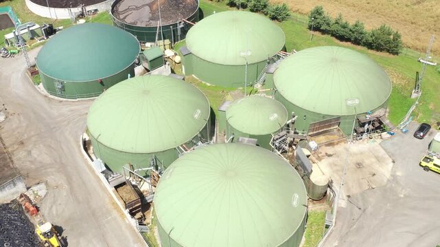 Biogas plant and farm in fields. Renewable energy from biomass. Agriculture prepared for Green Deal. Aerial view to Czech industry. Sustainable development in European Union.	