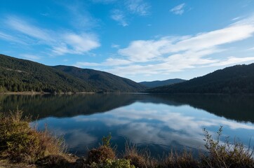 Fototapeta premium Reflection of the Serene Mountain Lake under the Clear Blue Sky
