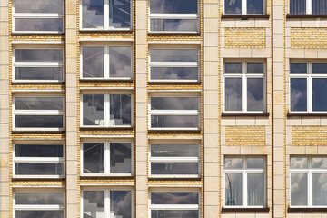 Facade of residential building. Many identical windows in a row. Symmetrical architecture pattern....