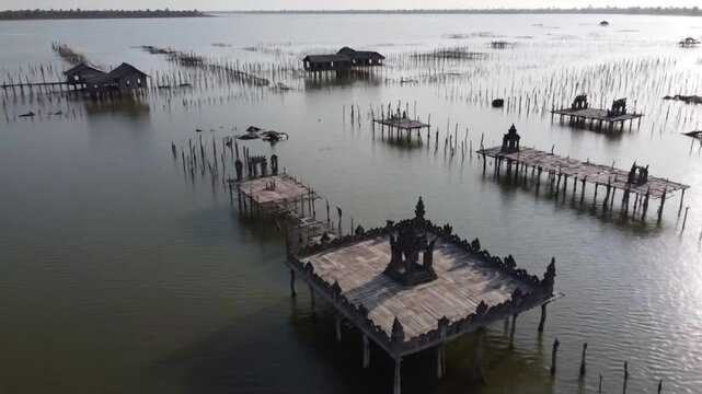 Ancient temple ruins emerge from the depths of a serene lake a silent testament to history s embrace under soft aerial
