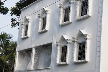 The facade of a white, multi-story residential building with traditional architectural design
