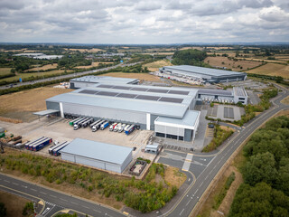 Large UK Logistics and Distribution Centre with Delivery Trucks, Solar Panels and Parking, Captured...
