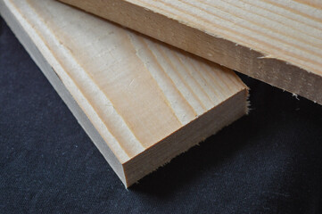 close-up of a hand holding a light wooden plank, showing texture and grain detail, concept of carpentry, DIY woodworking, or construction materials