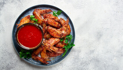 fried in the oven, chicken wings, with spices, tomato sauce, on a plate, gray background, no people, homemade,