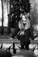 Portrait of a young beautiful long-haired girl in the early winter outdoors. Black and white photo.