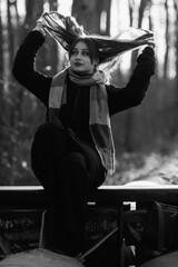 Portrait of a young beautiful long-haired girl in the early winter outdoors. Black and white photo.