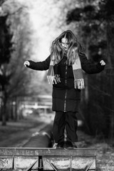 Portrait of a young beautiful long-haired girl in the early winter outdoors. Black and white photo.
