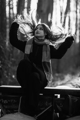 Portrait of a young beautiful long-haired girl in the early winter outdoors. Black and white photo.