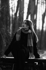 Portrait of a young beautiful long-haired girl in the early winter outdoors. Black and white photo.