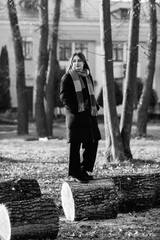 Portrait of a young beautiful long-haired girl in the early winter outdoors. Black and white photo.