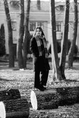 Portrait of a young beautiful long-haired girl in the early winter outdoors. Black and white photo.