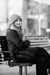 Portrait of a young beautiful long-haired girl in the early winter outdoors. Black and white photo.