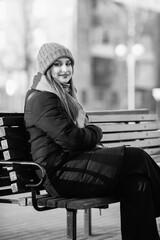Portrait of a young beautiful long-haired girl in the early winter outdoors. Black and white photo.